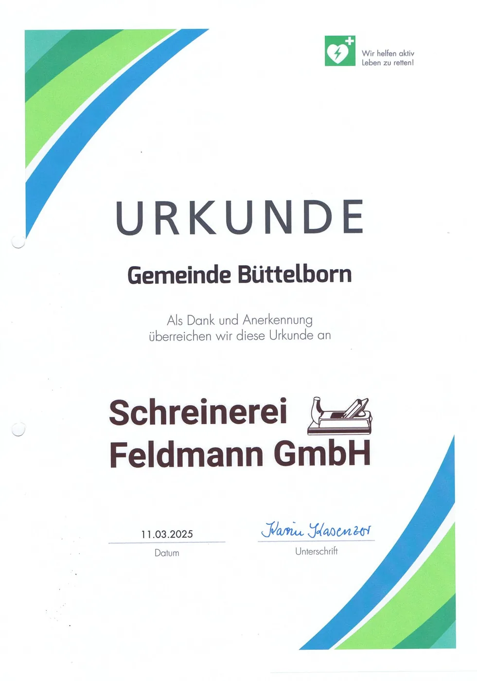 Urkunde der Gemeinde Büttelborn vom 11.03.2025: „Als Dank und Anerkennung überreichen wir diese Urkunde an Schreinerei Feldmann GmbH“ — unter dem Zeichen „Wir helfen aktiv Leben zu retten!“