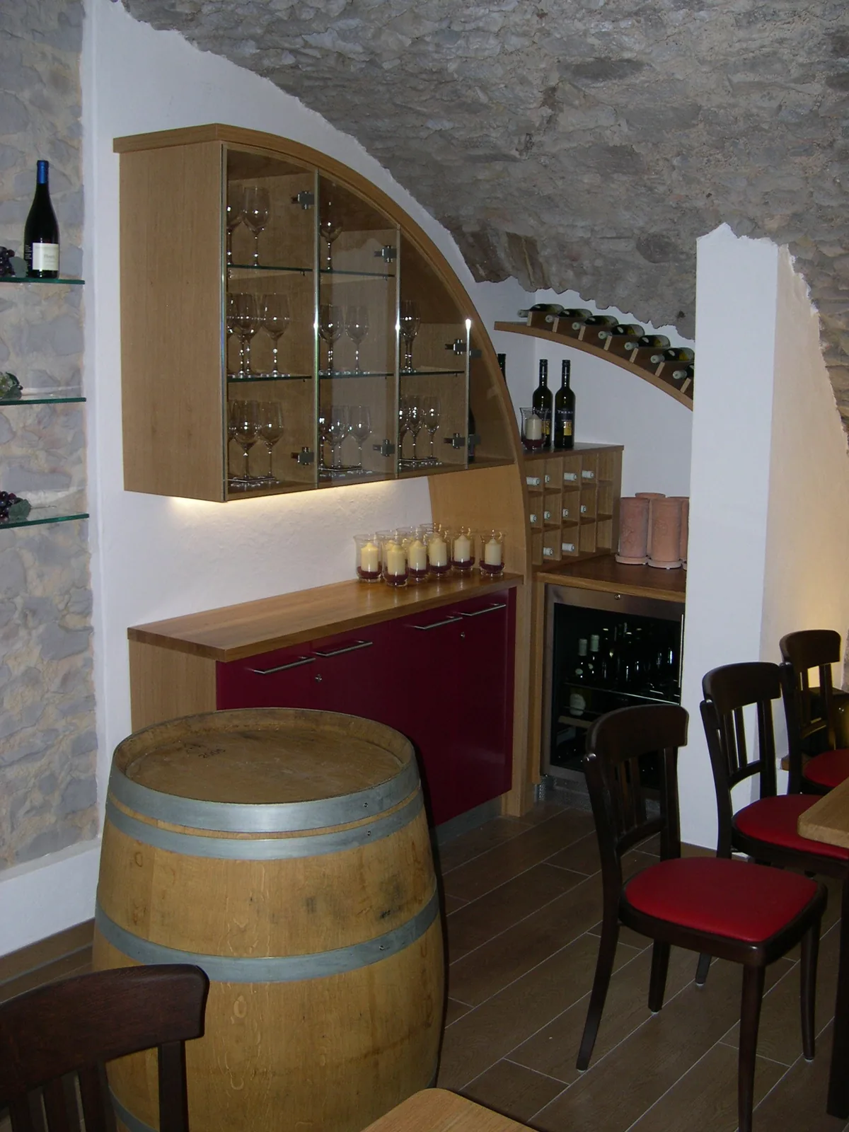Theke der Vinothek mit Bogenvitrine, Weinfass und Weinregal
